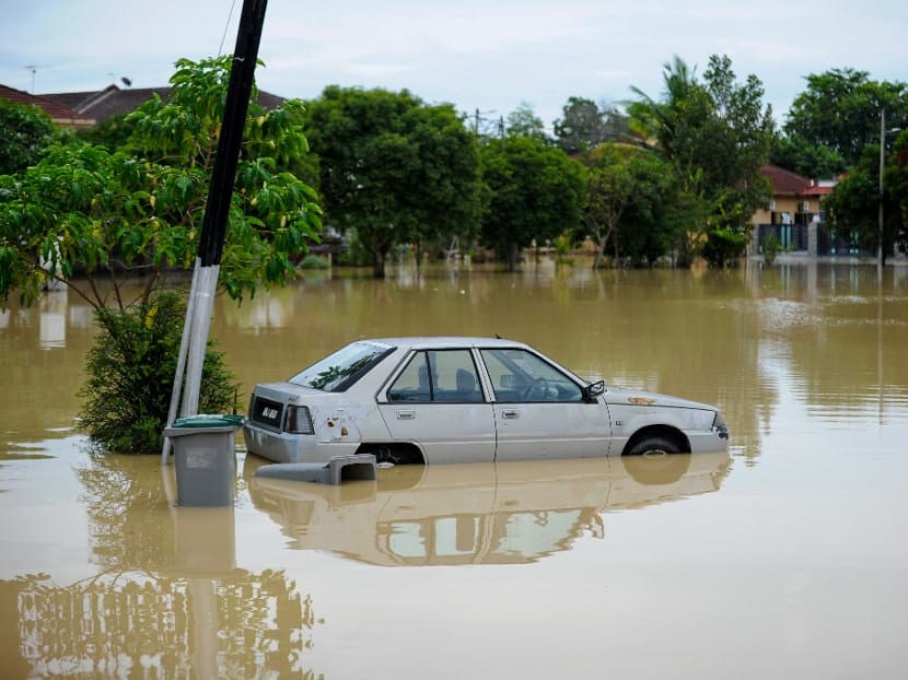 A car is seen partially submerged in floodwaters in a residential area in Batu Berendam in Malaysia's southern coastal state of Malacca on Jan 3, 2022.