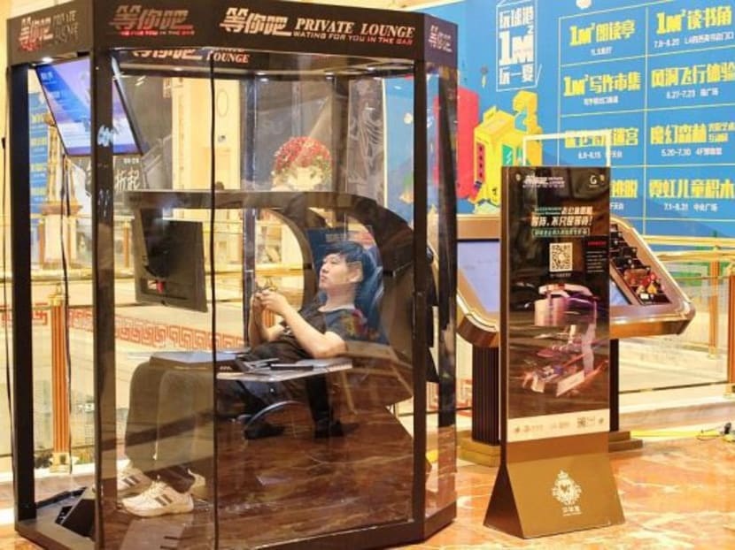 A man playing video games in a booth at a shopping mall in Shanghai. The futuristic mini man-caves are a first in China, say the makers Ingrem. Photo: AFP