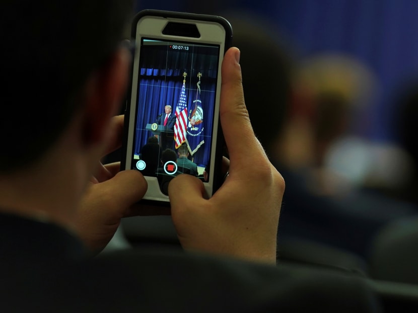 An attendee captures a video of U.S. President Donald Trump addressing the 'Face-to-Face With Our Future' event at the White House in Washington in June.