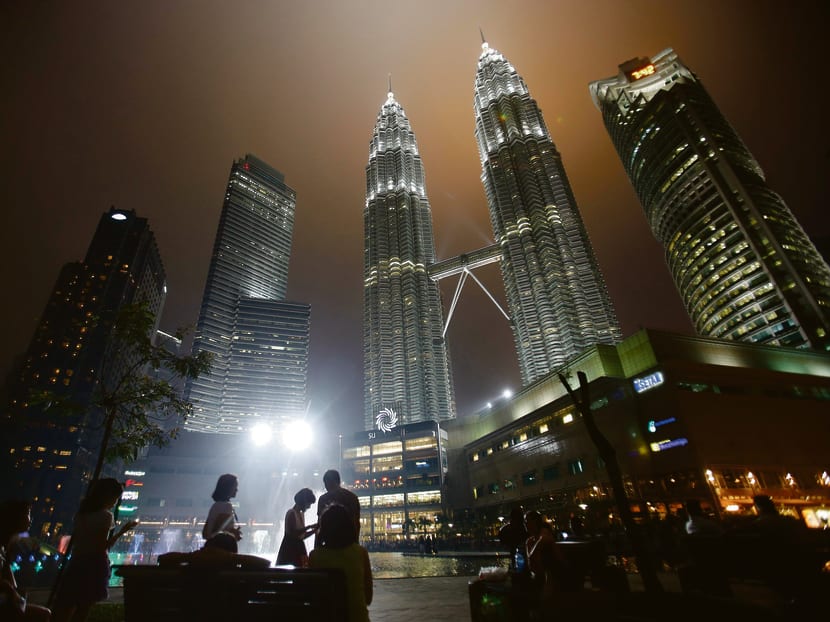Tourists gather near the foot of the Petronas Twin Towers in Kuala Lumpur. Reuters file photo