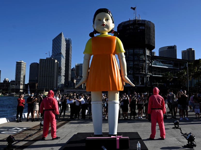 People visit a 4.5m tall replica doll from the Netflix series "Squid Game" on display at the harbour in Sydney on Oct 29, 2021. The series has been a worldwide phenomenon since its launch in September.