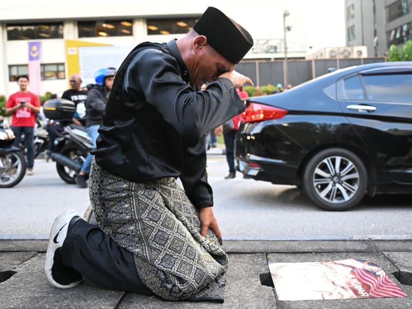 A supporter cries in front of a poster of Malaysia opposition leader Anwar Ibrahim outside the National Palace in Kuala Lumpur on Nov 22, 2022.
A supporter cries in front of a poster of Malaysia opposition leader Anwar Ibrahim outside the National Palace in Kuala Lumpur on Nov 22, 2022.