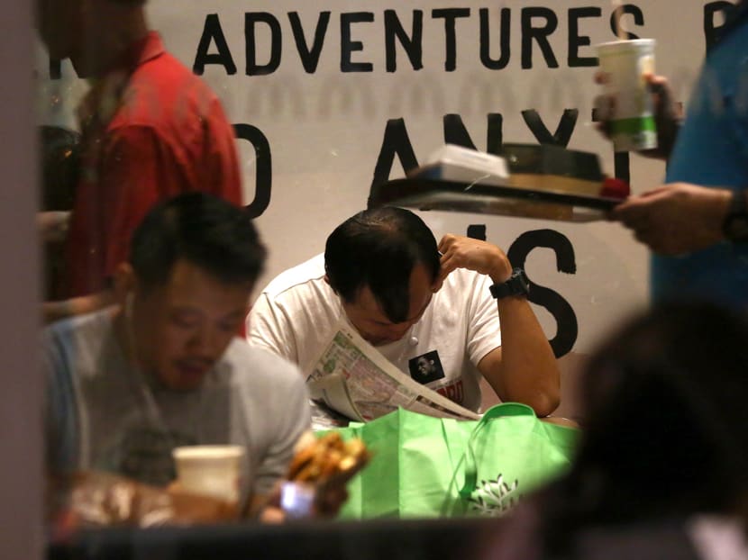 Mr Raymond Tan (centre) sleeps at the 24-hour outlets of fast-food chain McDonald’s, joining the people dubbed “McRefugees” or “McSleepers” who seek shelter at these places for the night -- but he is not jobless. Photo: Nuria Ling/TODAY