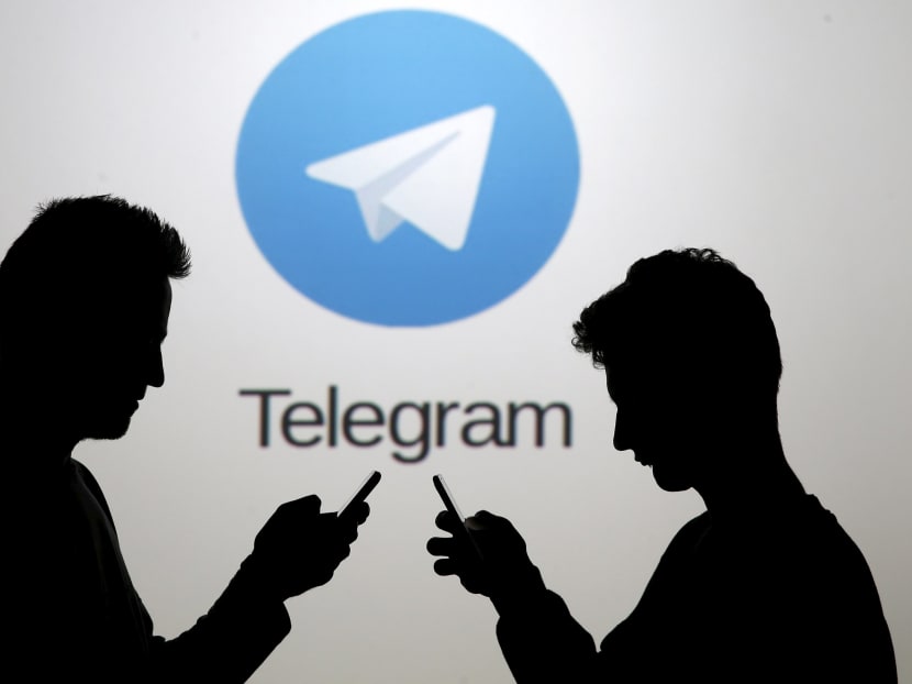 Two men pose with smartphones in front of a screen showing the Telegram logo in this picture illustration taken in Zenica, Bosnia and Herzegovina on Nov 18, 2015. Photo: Reuters