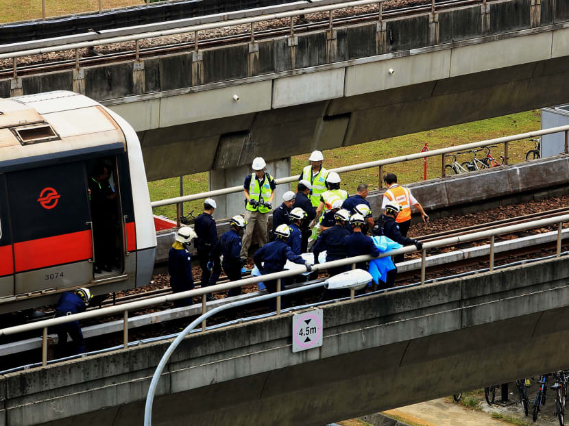 TODAY file photo of SCDF officers removing a body from the scene of the train accident at Pasir Ris MRT Station, which left two SMRT employees dead.