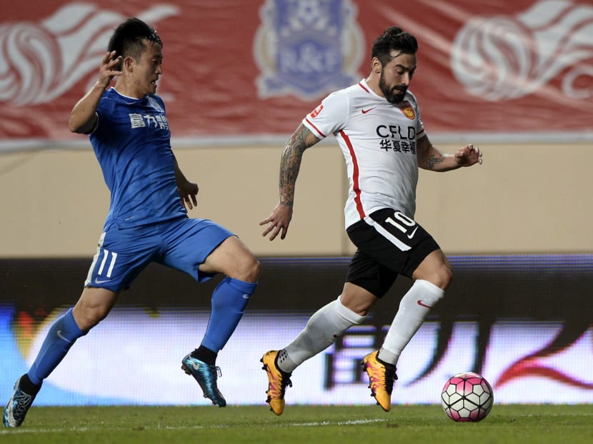 Ezequiel Lavezzi (R) of Hebei CFFC dribbles the ball past Jiang Zhipeng of Guangzhou R&F during their Chinese Super League football match in Guangzhou on March 4, 2016. Photo: AFP