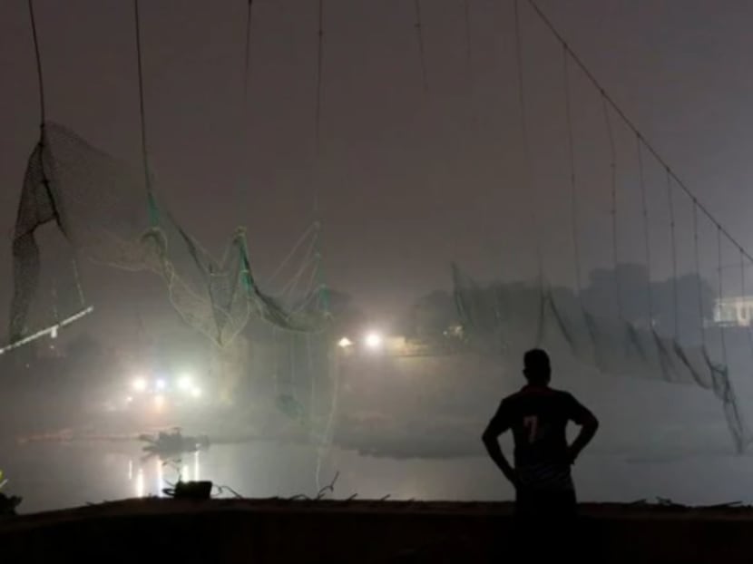 A security personnel stands near a damaged suspension bridge after it collapsed on Sunday, Oct 30, 2022, in Morbi town in the western state of Gujarat, India, Nov 1, 2022. 

