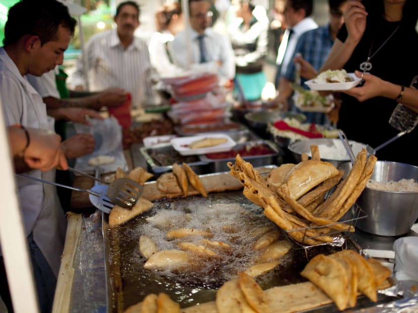 A street vendor fries food for customers during lunch time in Mexico City, Wednesday, July 10, 2013. Mexico has surpassed the United States in levels of adult obesity. Almost one-third of adult Mexicans, 32.8 per cent, are obese compared to 31.8 per cent of Americans, according to the U.N. Food and Agriculture Organization, or FAO. Photo: AP