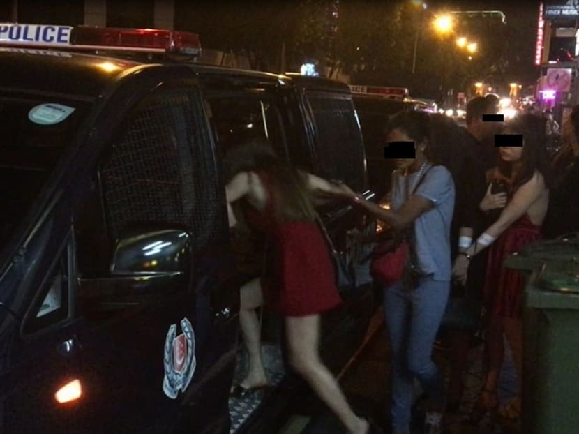 A woman detained for illegal employment offences at a public entertainment outlet. Photo: Singapore Police Force