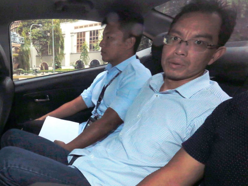 Yan Jun (right) entering the State Courts in a police car in July 2017.