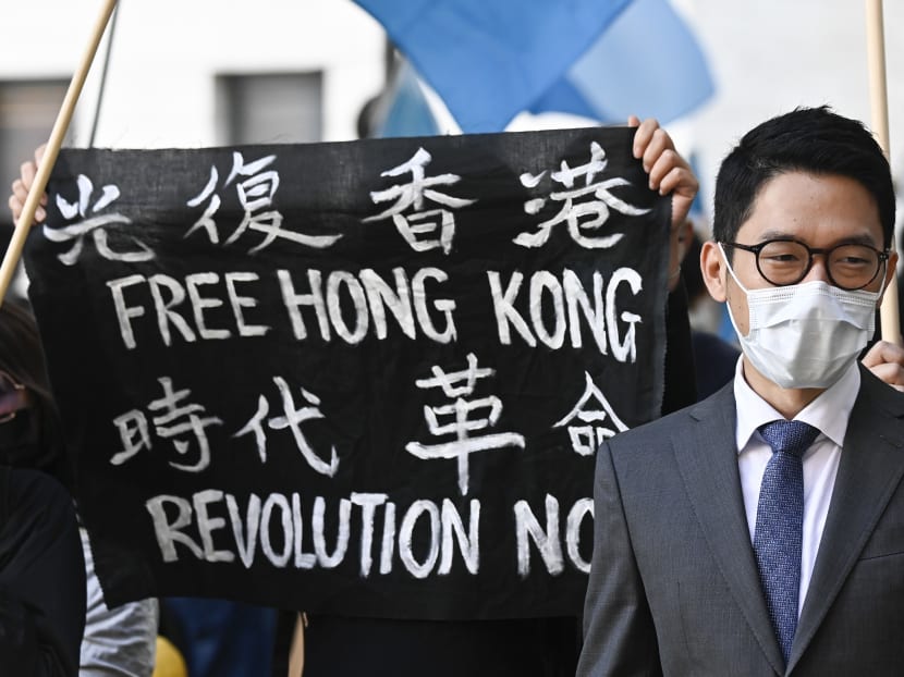 Hong Kong democracy activist Nathan Law stands next to a banner reading "Free Hong Kong. Revolution now" as he attends a demonstration on Sept 1, 2020 outside the Foreign Office in Berlin, where the Chinese Foreign Minister was expected to hold talks with his German counterpart.