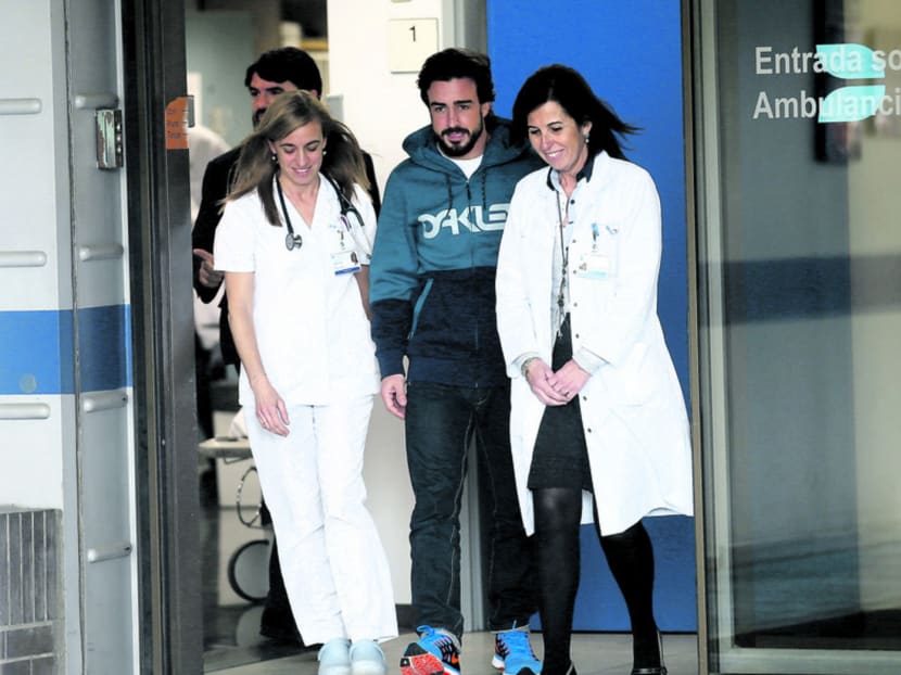 Alonso (centre) with medical staff last month while leaving the hospital north of Barcelona, where he was warded after his accident. He is said to be concerned by the unexplained circumstances that surrounded the event at the Circuit de Catalunya. Photo: Reuters