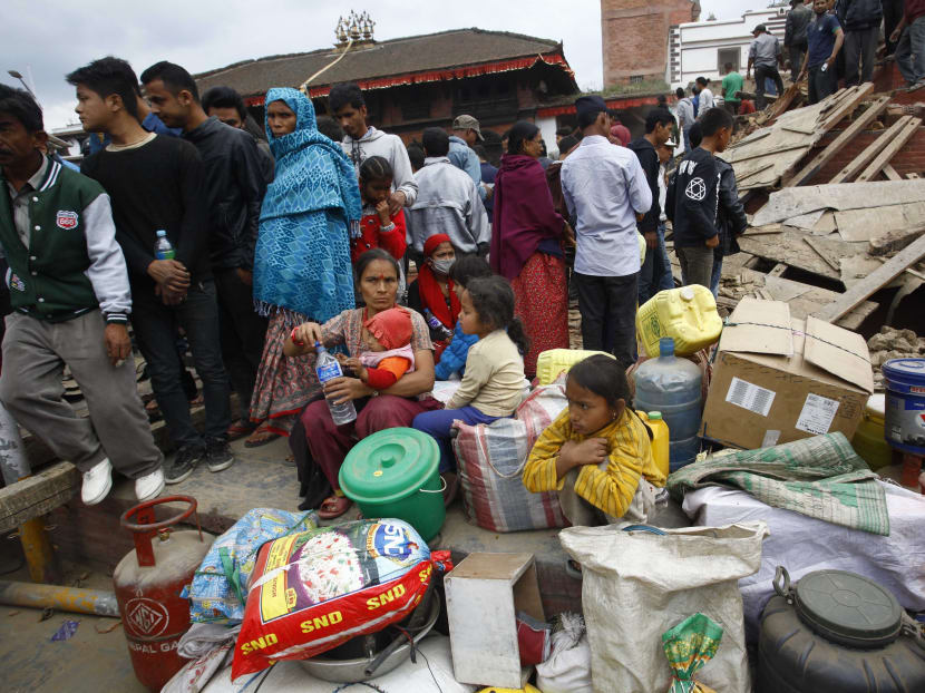 People gather beside damaged buildings after an earthquake in Kathmandu, capital of Nepal, Saturday, April 25, 2015.  Photo: Xinhua/AP