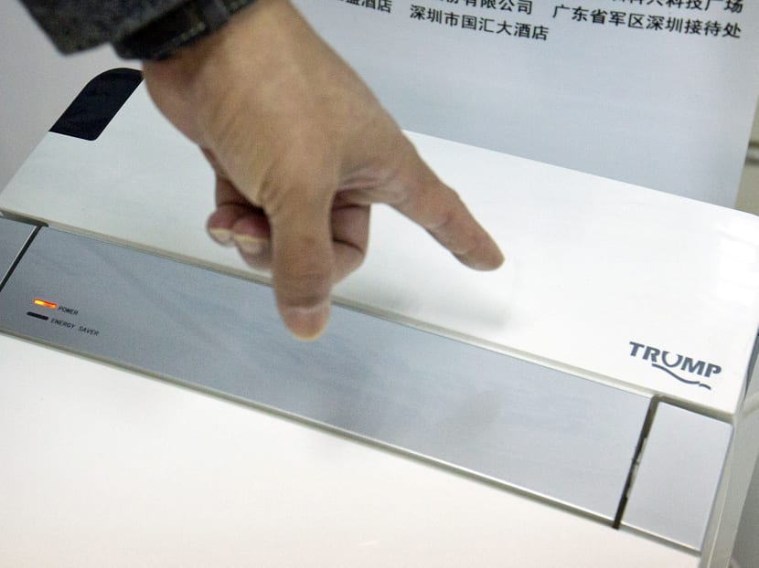Co-founder of Shenzhen Chuangpu Industrial Co,  Zhong Jiye pointing to the logo on one of his firm's high-end Trump-branded toilets at the company's offices in Shenzhen in southern China's Guangdong Province. Photo: AP