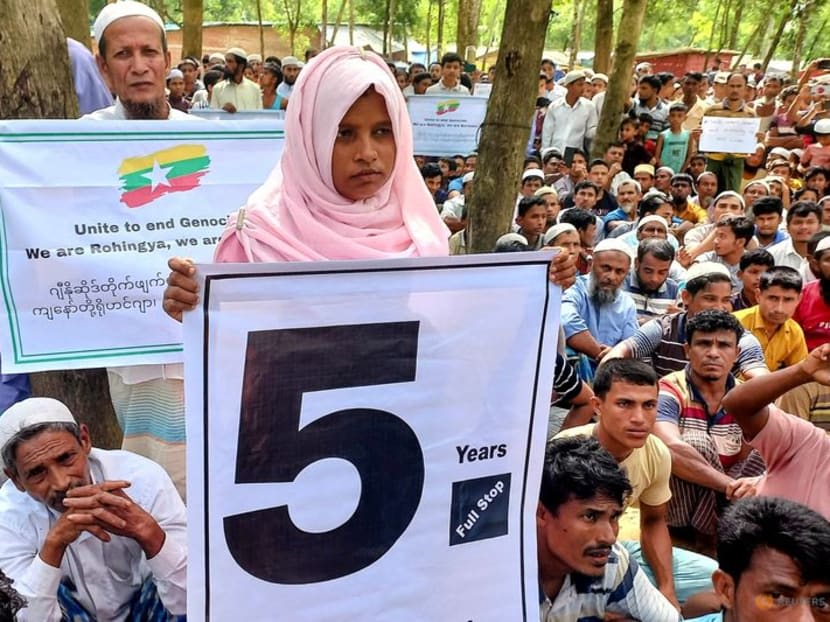Rohingya refugees hold placards as they gather at the Kutupalong Refugee Camp to mark the fifth anniversary of their fleeing from neighbouring Myanmar to escape a military crackdown in 2017, in Cox's Bazar, Bangladesh, Aug 25, 2022. 