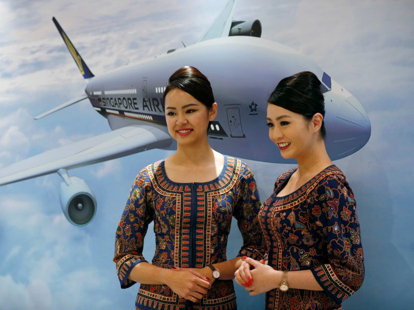 Singapore Airlines flight attendants pose for photos at a presentation of the airlines' newly launched cabin products in Singapore, Nov 2.