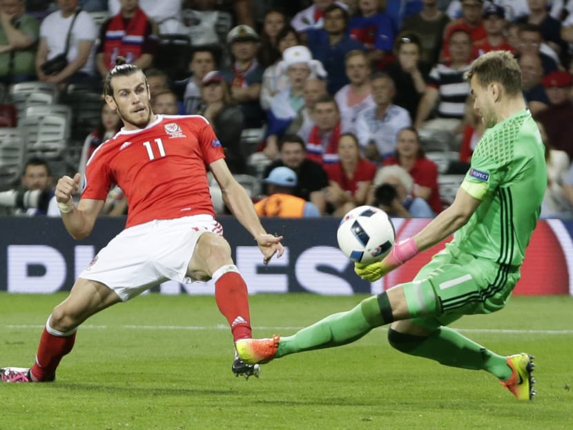 Wales' Gareth Bale, left, scores his side's third goal past Russia goalkeeper Igor Akinfeev during the Euro 2016 Group B soccer match between Russia and Wales at the Stadium municipal in Toulouse, France, Monday, June 20, 2016. Photo: AP