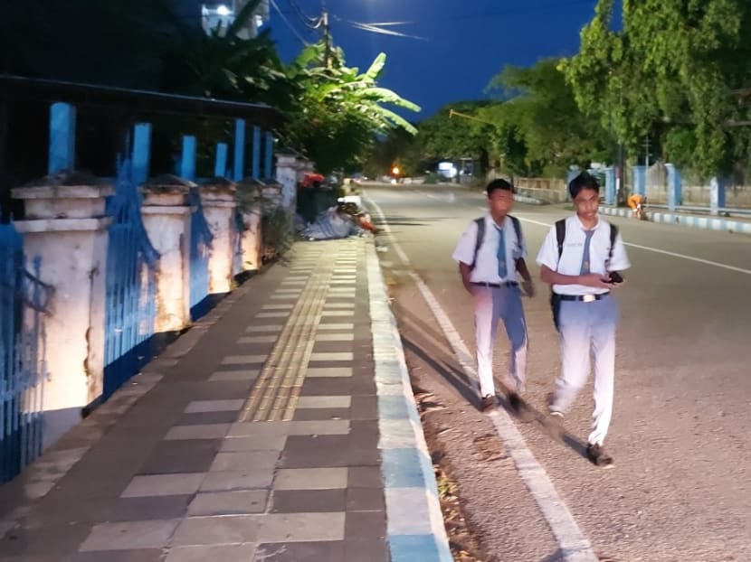 This picture taken on March 6, 2023 shows high school students walking to school early in the morning in Kupang.