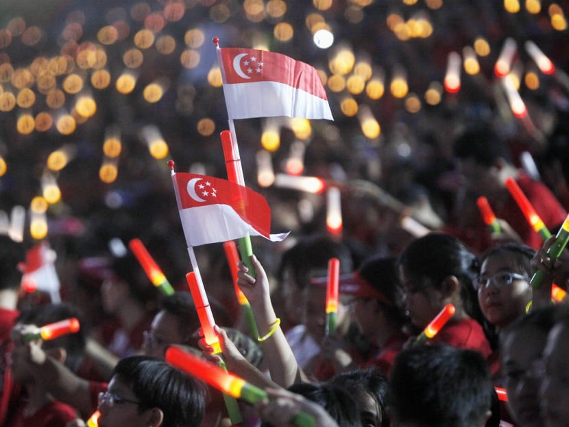Participants waving the Singapore flag at the National Day Parade 2014. TODAY file photo