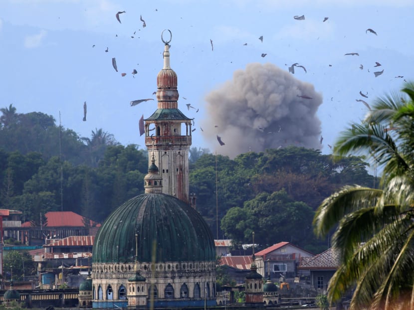 Debris and smoke are seen after an OV-10 Bronco aircraft released a bomb, during an airstrike at Marawi city. Reuters file photo