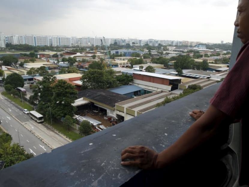 A man looking at a cluster of factories at an industrial park in Singapore. A man looking at a cluster of factories at an industrial park in Singapore.