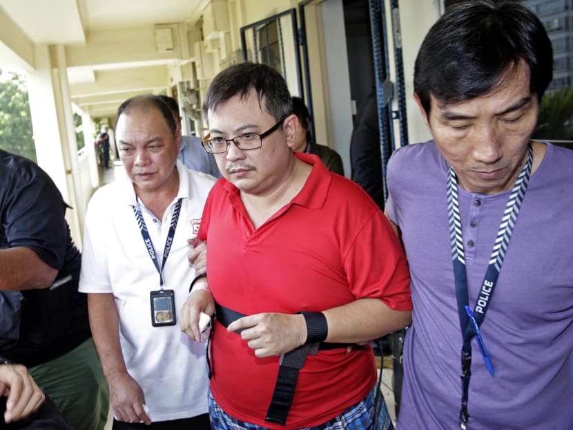 Woodlands murder suspect Teo Ghim Heng (second from right) being escorted back to the crime scene on Feb 10, 2017. 