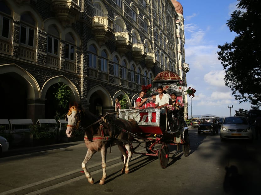 A family enjoys a ride on a horse drawn carriage popularly known as "Victoria carriage" outside the Taj Mahal hotel in Mumbai, India, in this June 9, 2015 photo. Photo: AP