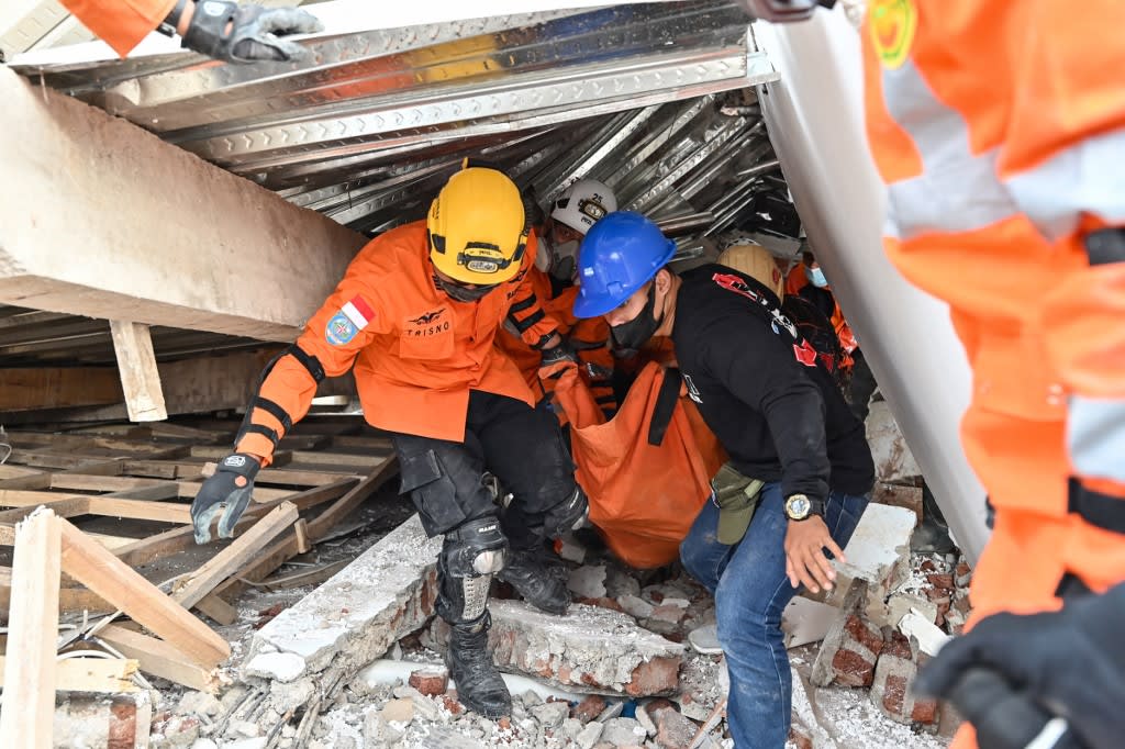 Rescue workers carry the body of a victim in Cianjur on Nov 22, 2022, following a 5.6-magnitude earthquake. Rescue workers carry the body of a victim in Cianjur on Nov 22, 2022, following a 5.6-magnitude earthquake.