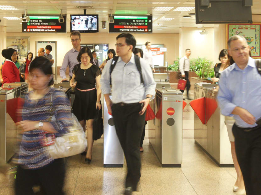 Commuters at Raffles Place MRT Station. Transport Minister Lui Tuck Yew has announced that there will be a travel free trial from 24 June 2013 to 23 June 2014 where MRT rides to city areas if one taps out before 7:45am would be free. Photo by OOI BOON KEONG.
