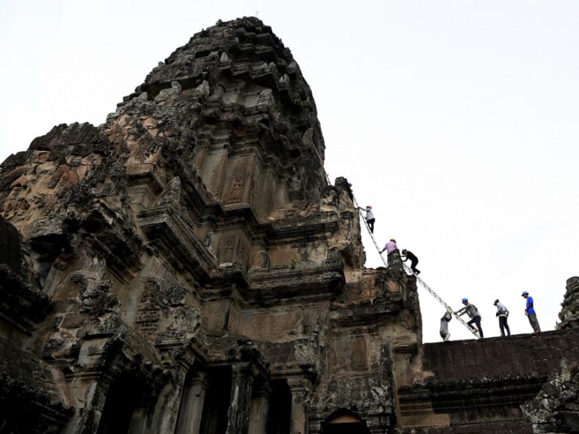 This photo taken on Oct 12, 2020 shows gardeners preparing to climb up the tower of the Angkor Wat temple to remove tree saplings growing on the temple's exterior in Siem Reap province.