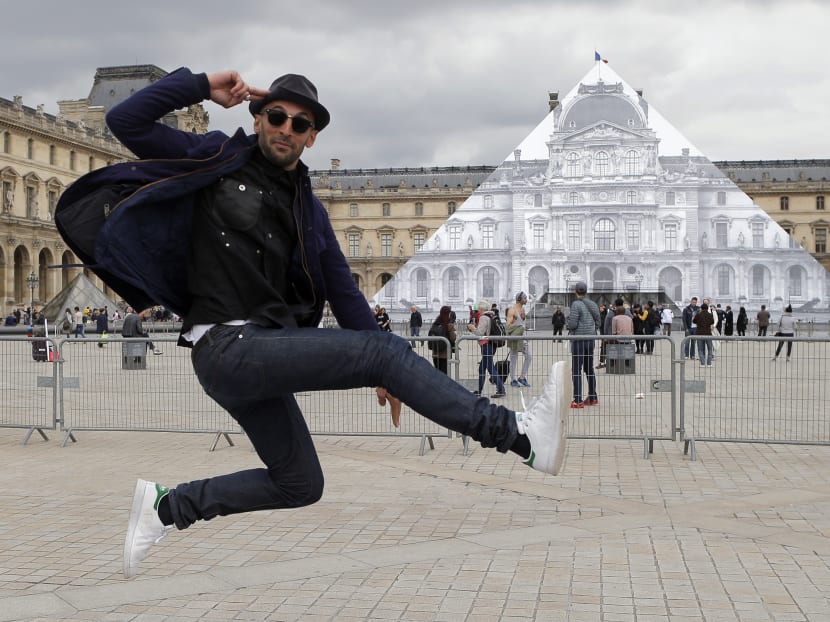 Street artist JR poses in front the Louvre Pyramid in Paris. Photo: AP