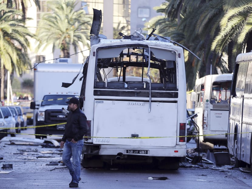 A man walks past the bus that exploded yesterday in Tunis,  on Nov 25, 2015. Photo: AP
