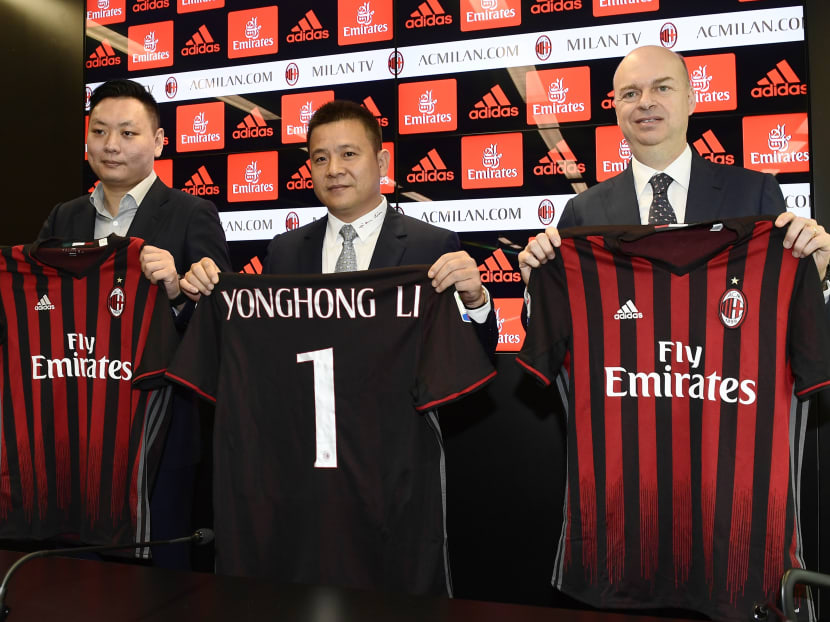 Chinese businessman and owner of AC Milan FC, Li Yonghong (centre), poses with his team jersey. Photo: AFP