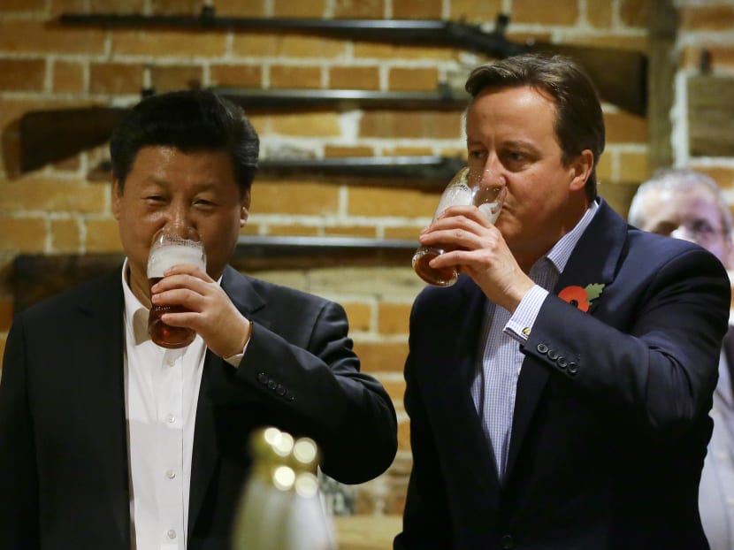 This file photo taken on Oct 22, 2015 shows British Prime Minister David Cameron (R) drinking a pint of beer with Chinese President Xi Jinping at the Plough pub in Princess Risborough near Chequers.
 Photo: AFP