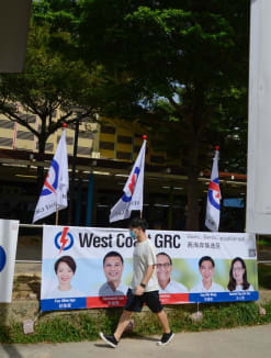 A pedestrian walking by a People's Action Party banner in West Coast Group Representation Constituency during the General Election campaign in 2020.