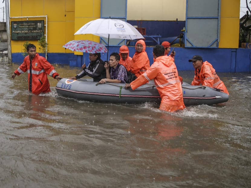Flood-affected residents use a rubber boat in an inundated neighbourhood in Jakarta. Photo: AFP