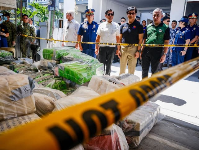 Philippine President Ferdinand Marcos (centre, in white shirt) and Interior Secretary Benhur Abalos (second from right) inspect seized methamphetamine drugs in Alitagtag town in Batangas province on April 16, 2024.