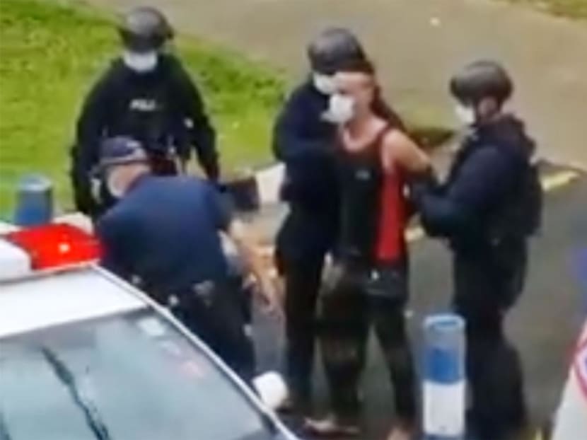 A screenshot from a video of Fadhil Yusop being apprehended by police officers on March 14, 2022.