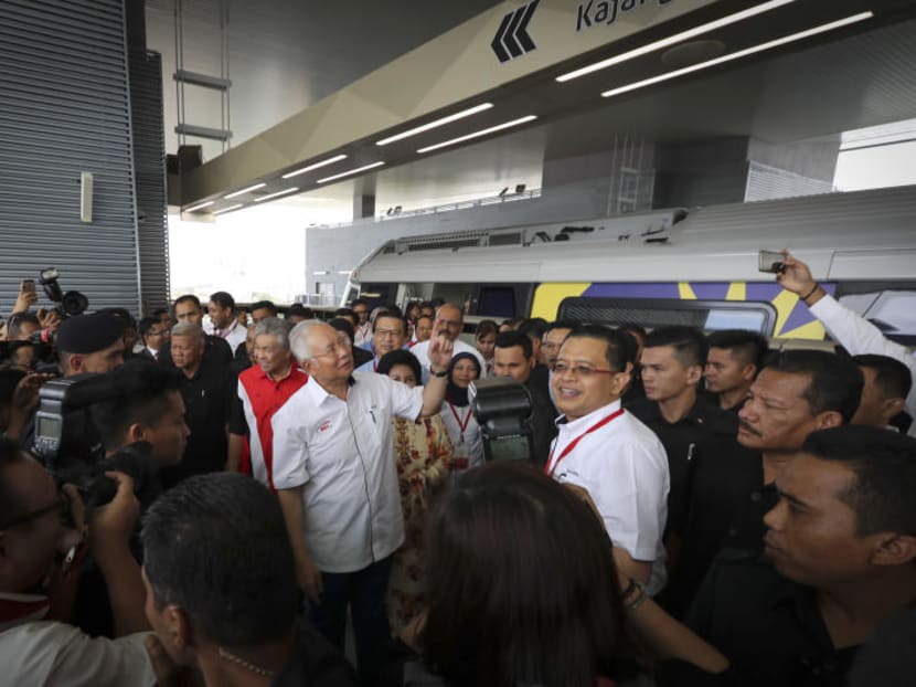 Malaysian Prime Minister Najib Razak (centre) pointing to a Mass Rapid Transit (MRT) station signboard as he arrives at the newly opened MRT Line in Kajang, on the outskirts of Kuala Lumpur on Monday, July 17, 2017. The launch marked a significant milestone in the government's continuous effort to enhance and improve urban public transportation network particularly in the Klang Valley region. Photo: AP