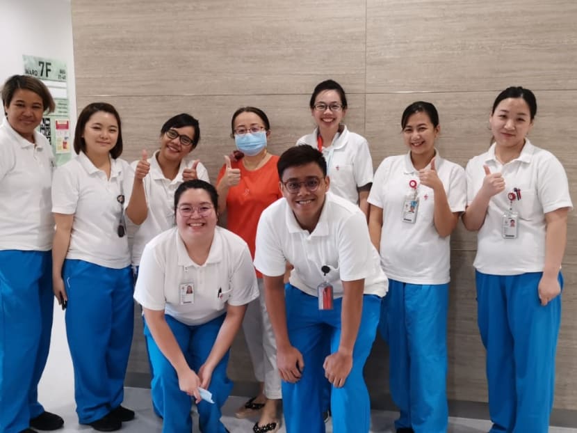 NCID healthcare staff bid a fond farewell to Mrs Zhang (in orange), who is cleared of the virus. Mrs Zhang is donning a mask as she would like to remain anonymous.