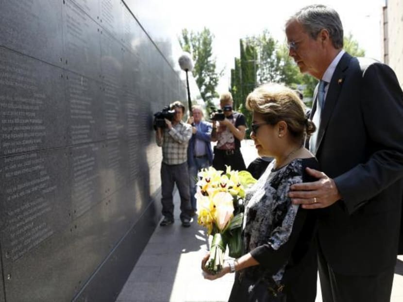 Former Florida Governor and potential Republican presidential candidate Jeb Bush with his wife Columba pay honour in front of the Memory Wall at the Warsaw Uprising Museum in Warsaw, Poland, on June 11, 2015. Photo: Reuters
