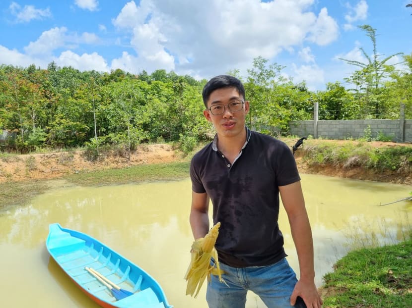 The writer enjoying grilled corn at a small farm in Kampong Speu province in Cambodia.