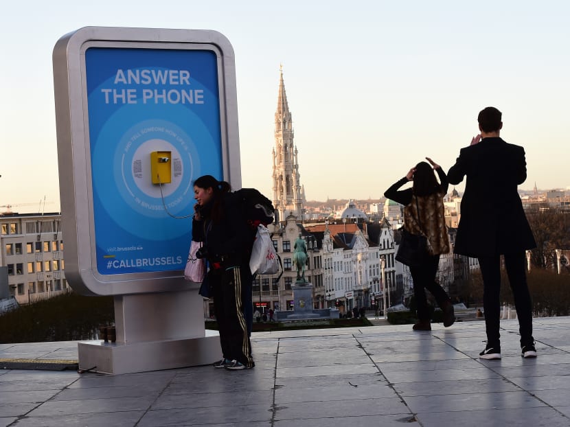 A woman answers a phone, a call box to which internet surfers from around the world can make a call to and randomnly get news from passers-by about the safety of life in Brussels, on Jan 8, 2016. Photo: AFP A woman answers a phone, a call box to which internet surfers from around the world can make a call to and randomnly get news from passers-by about the safety of life in Brussels, on Jan 8, 2016. Photo: AFP