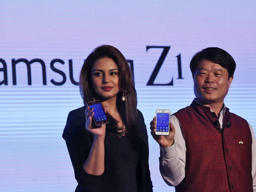 Hyun Chil Hong (right), president and chief executive of Samsung India Electronics, and Bollywood actress Huma Qureshi hold the Samsungs new Z1 smartphones at its launch in New Delhi Jan 14, 2015. Photo: Reuters