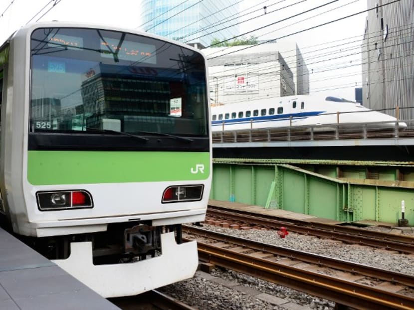 A train of Yamanote Line of East Japan Railway (JR East) runs beside a Shinkansen bullet train (right) in Tokyo.  Photo: AFP