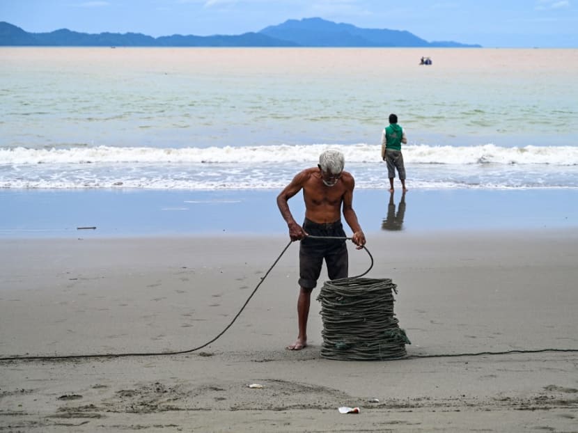 A fishermen sorts his rope on a beach in Banda Aceh on Oct 22, 2022.