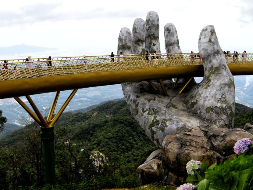 Photo of the day: Visitors walking along the 150m long Cau Vang "Golden Bridge" in the Ba Na Hills near Danang. Nestled in the forested hills of central Vietnam two giant concrete hands emerge from the trees, holding up a glimmering golden bridge crowded with gleeful visitors taking selfies at the country's latest eccentric tourist draw.