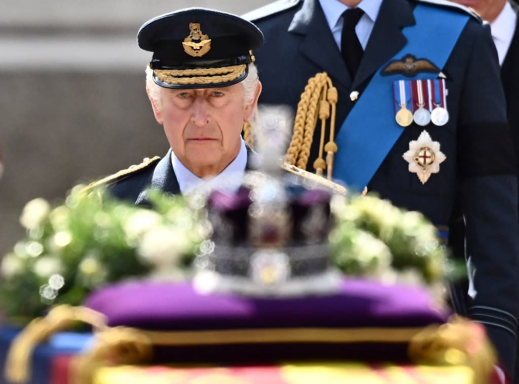 Britain's King Charles III walks behind the coffin of Queen Elizabeth II, adorned with a Royal Standard and the Imperial State Crown and pulled by a Gun Carriage of The King's Troop Royal Horse Artillery, during a procession from Buckingham Palace to the Palace of Westminster, in London on Sept 14, 2022.