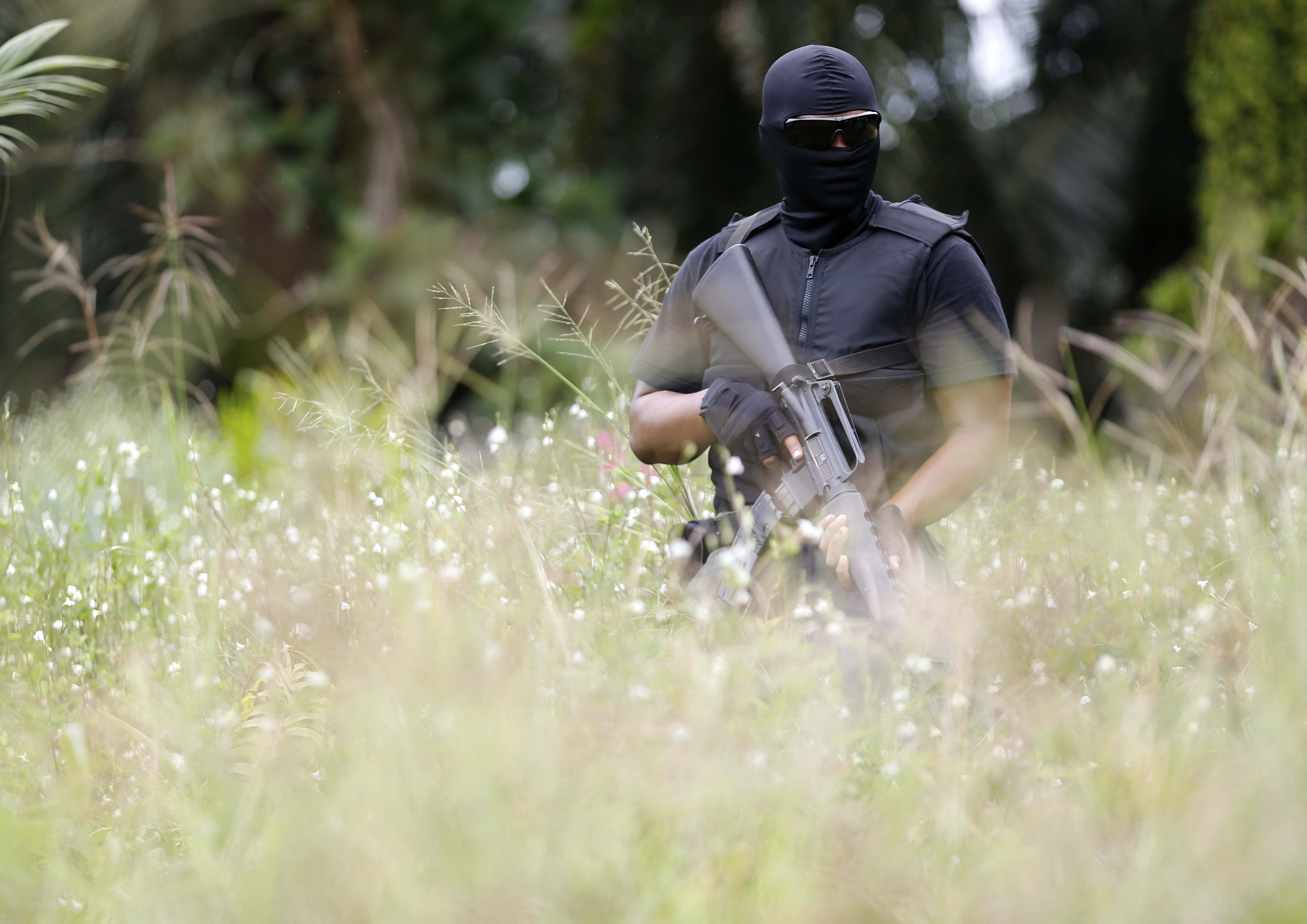 A special police force guards the area about three kilometres away from the location where armed men are holding off, during a visit by a minister in Sahabat 17 plantation farm, outside Lahad Datu on Borneo island on Feb 19, 2013. 