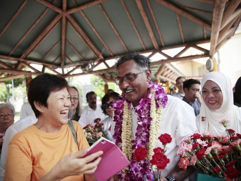 Mr Murali handing out flowers to Bukit Batok residents for Mother’s Day yesterday. He focused his campaign on how he would serve residents, and went about the hustings with no grandstanding. Photo: Jason Quah